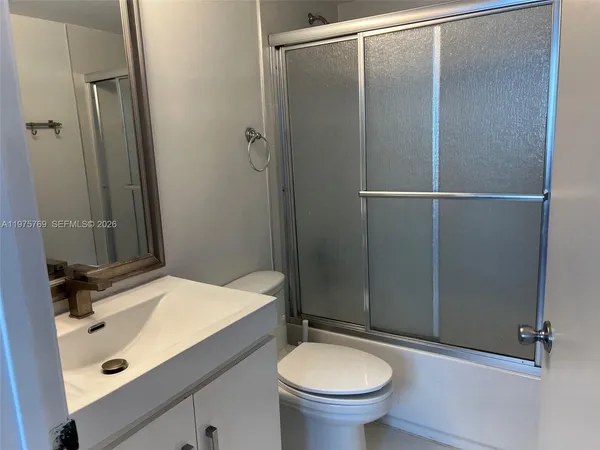 a white toilet sitting next to a bathroom sink
