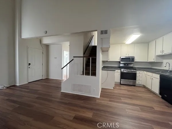 a kitchen with granite countertop a refrigerator and a stove top oven