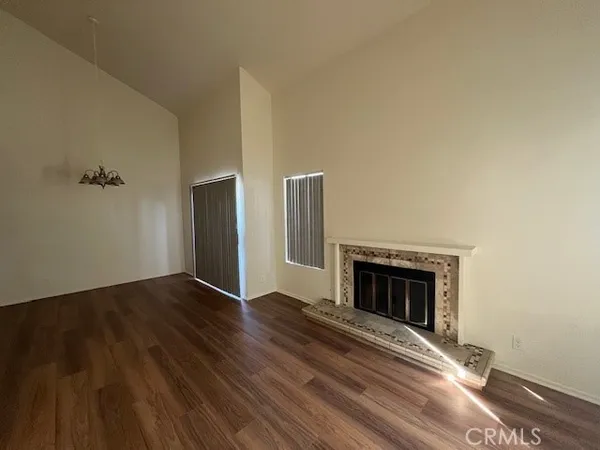a view of empty room with wooden floor and fireplace