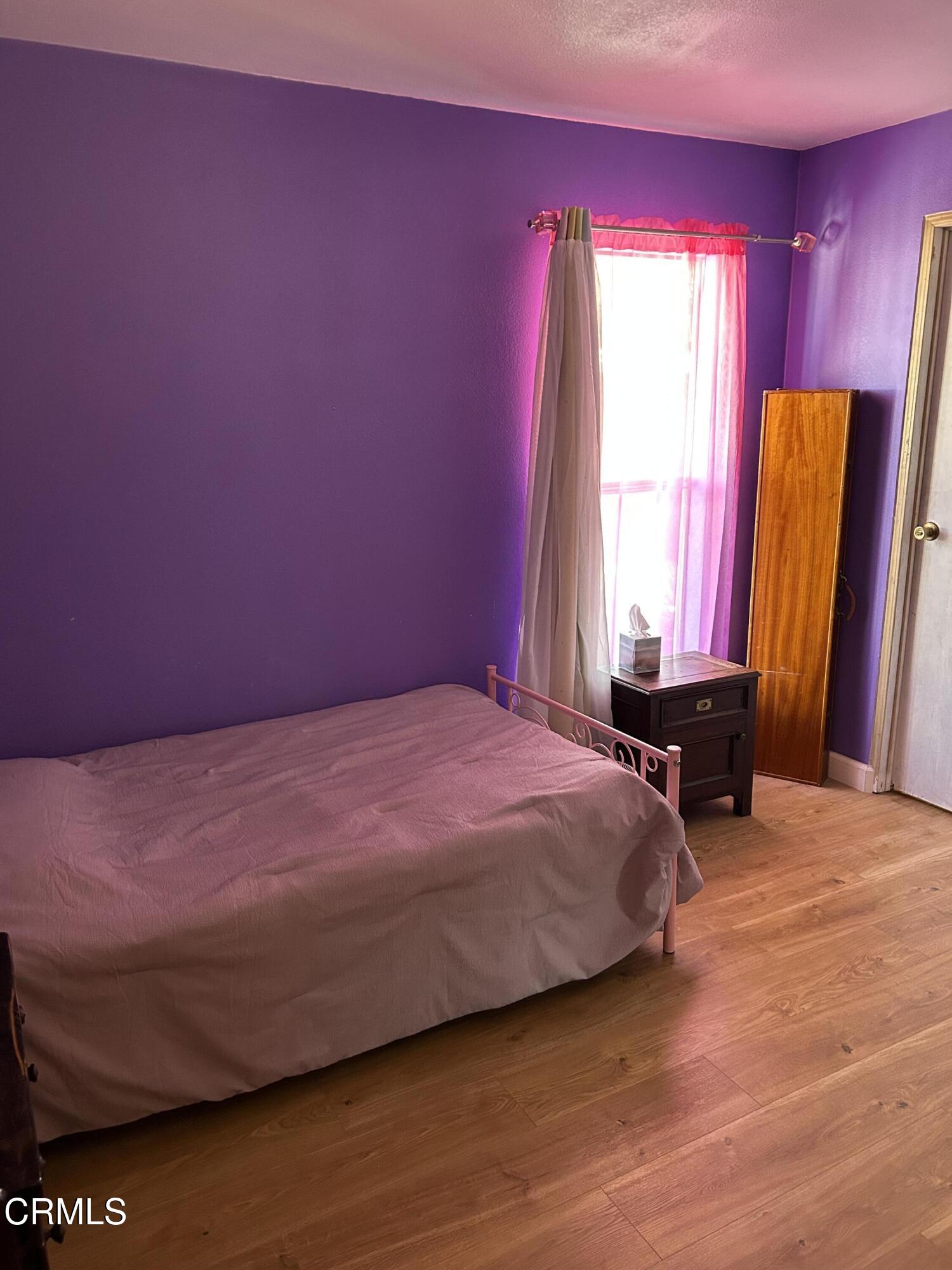 142 Geranium Way, Unit 142 Ventura, CA 93004 - Photo 19 of 23 a bedroom with a bed and wooden floor