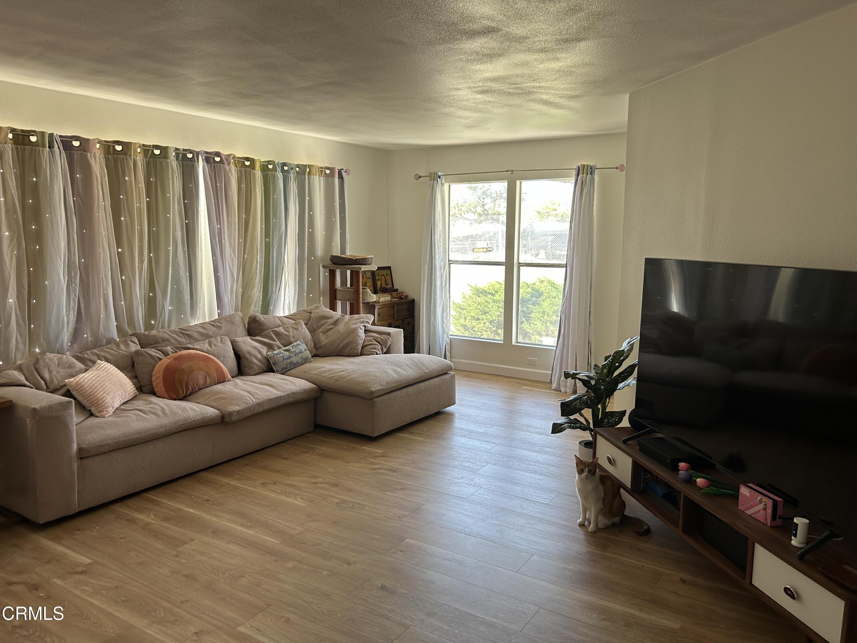 142 Geranium Way, Unit 142 Ventura, CA 93004 - Photo 2 of 23 a living room with furniture and a flat screen tv