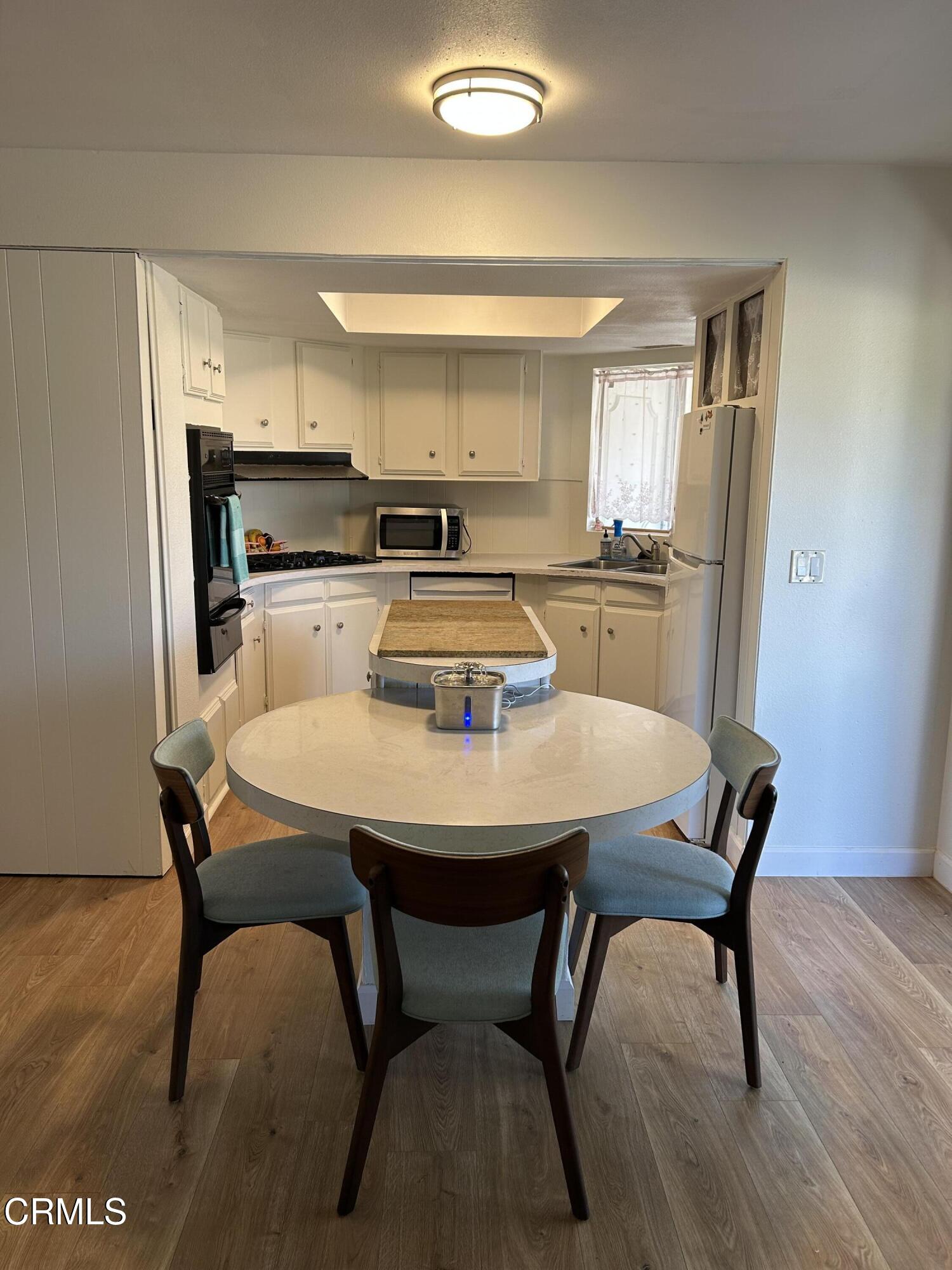142 Geranium Way, Unit 142 Ventura, CA 93004 - Photo 4 of 23 a dining room with furniture and wooden floor