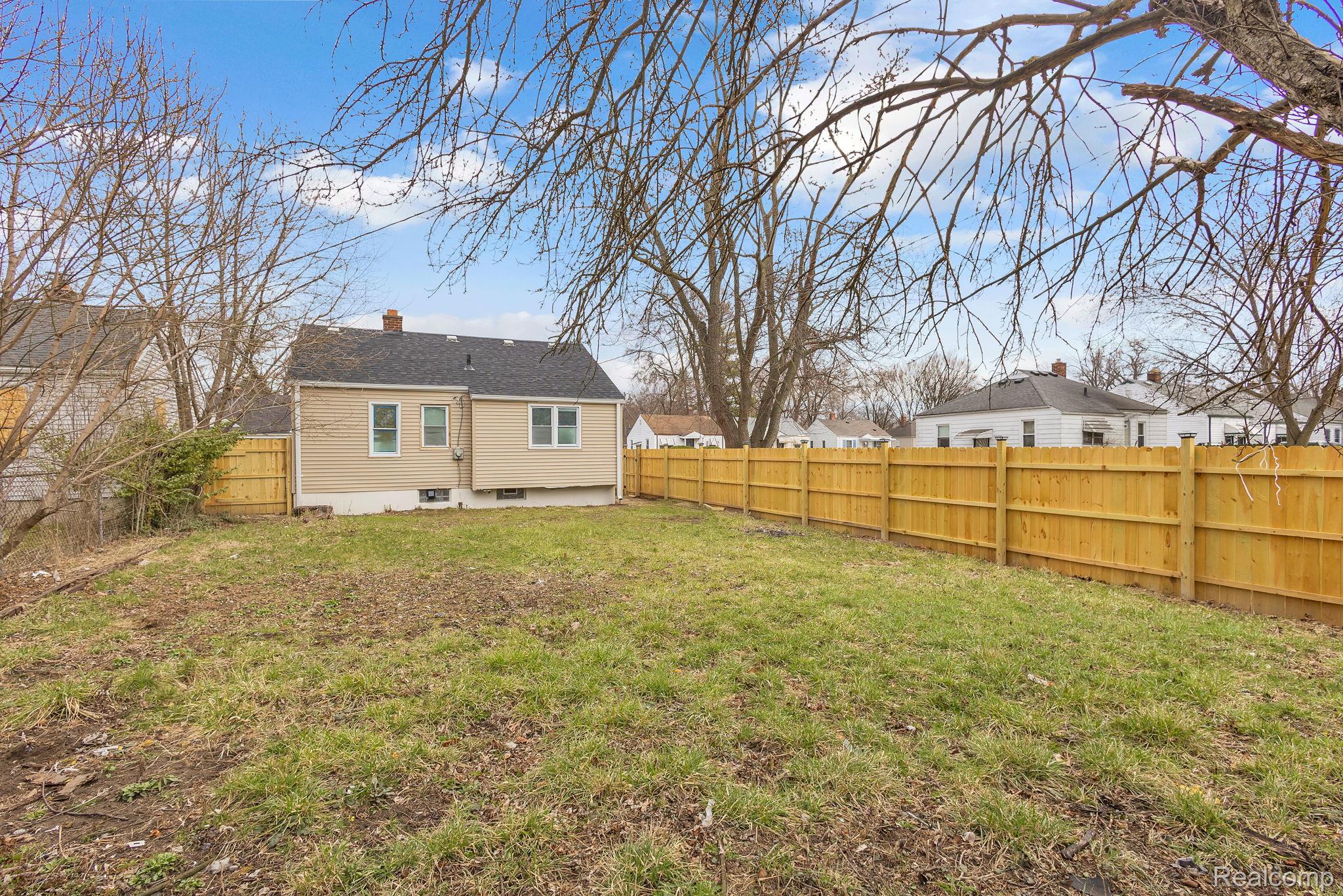 8401 Fielding Street Detroit, MI 48228 - Photo 27 of 34 Rear view of property featuring a fenced backyard, a chimney, a patio, and a residential view