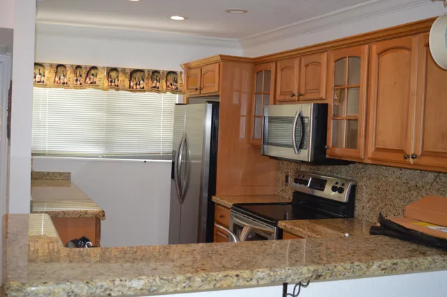 a kitchen with stainless steel appliances granite countertop a refrigerator and a sink