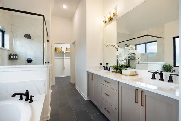 a spacious bathroom with a double vanity sink mirror and shower
