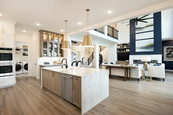 a large white kitchen with lots of counter space and stainless steel appliances