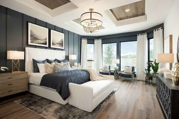 a spacious bedroom with a bed a chandelier and large window