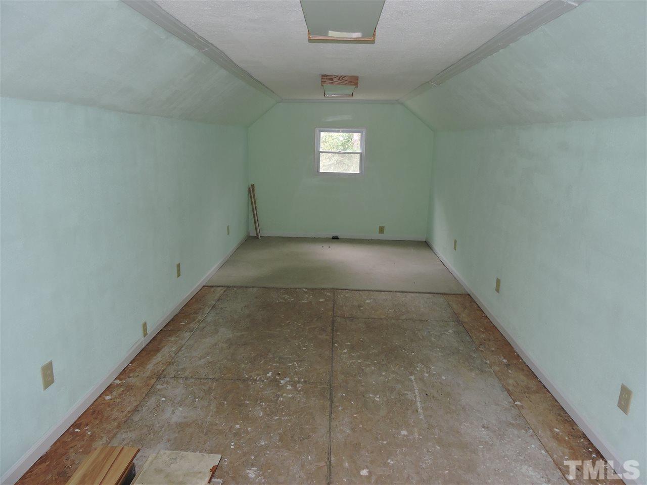 49 Epps Martin Road Roxboro, NC 27574 - Photo 19 of 25 an empty room with a chandelier fan and windows