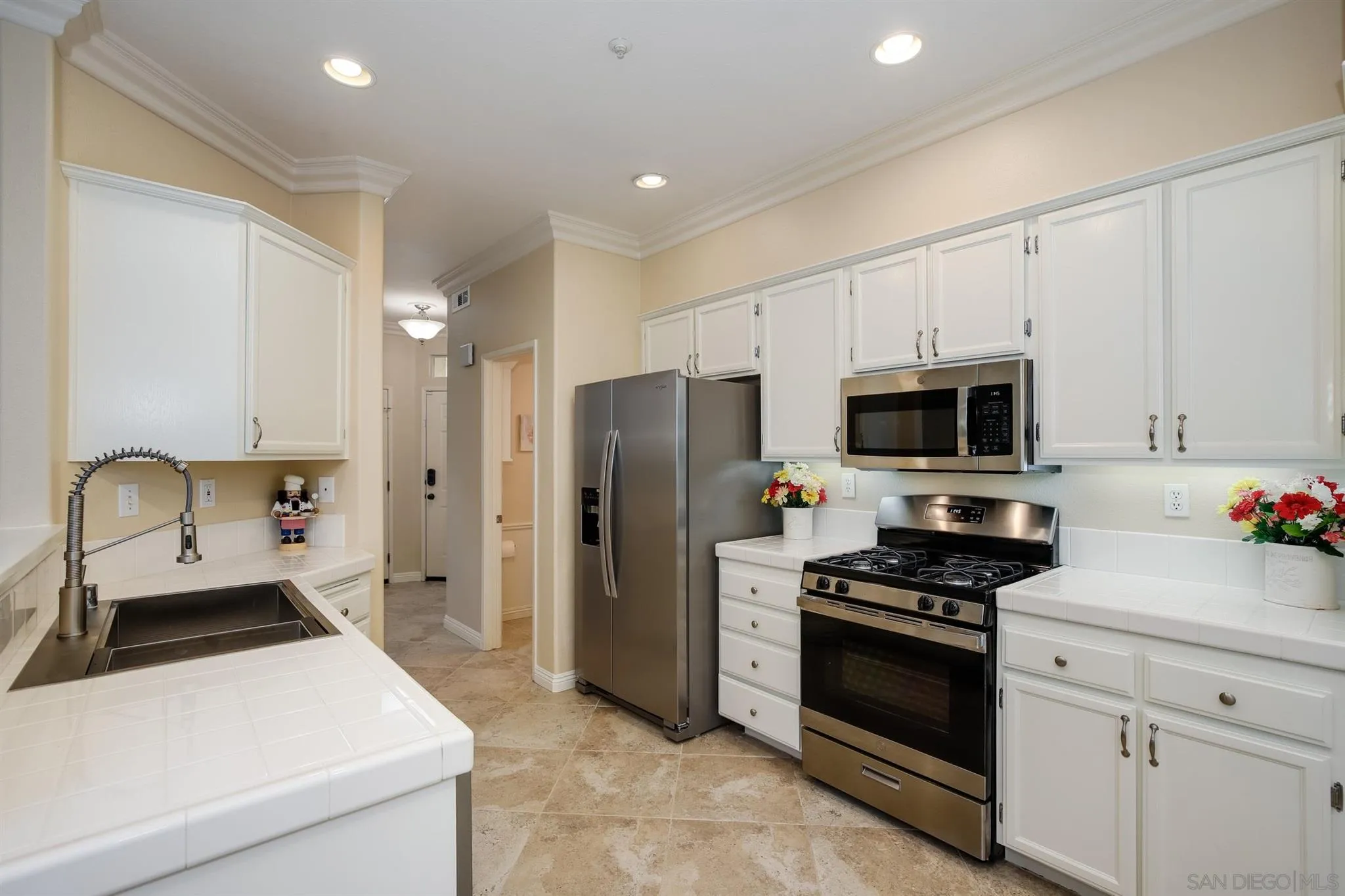 1983 Courage Street Vista, CA 92081 - Photo 11 of 33 a kitchen with stainless steel appliances a refrigerator stove and white cabinets