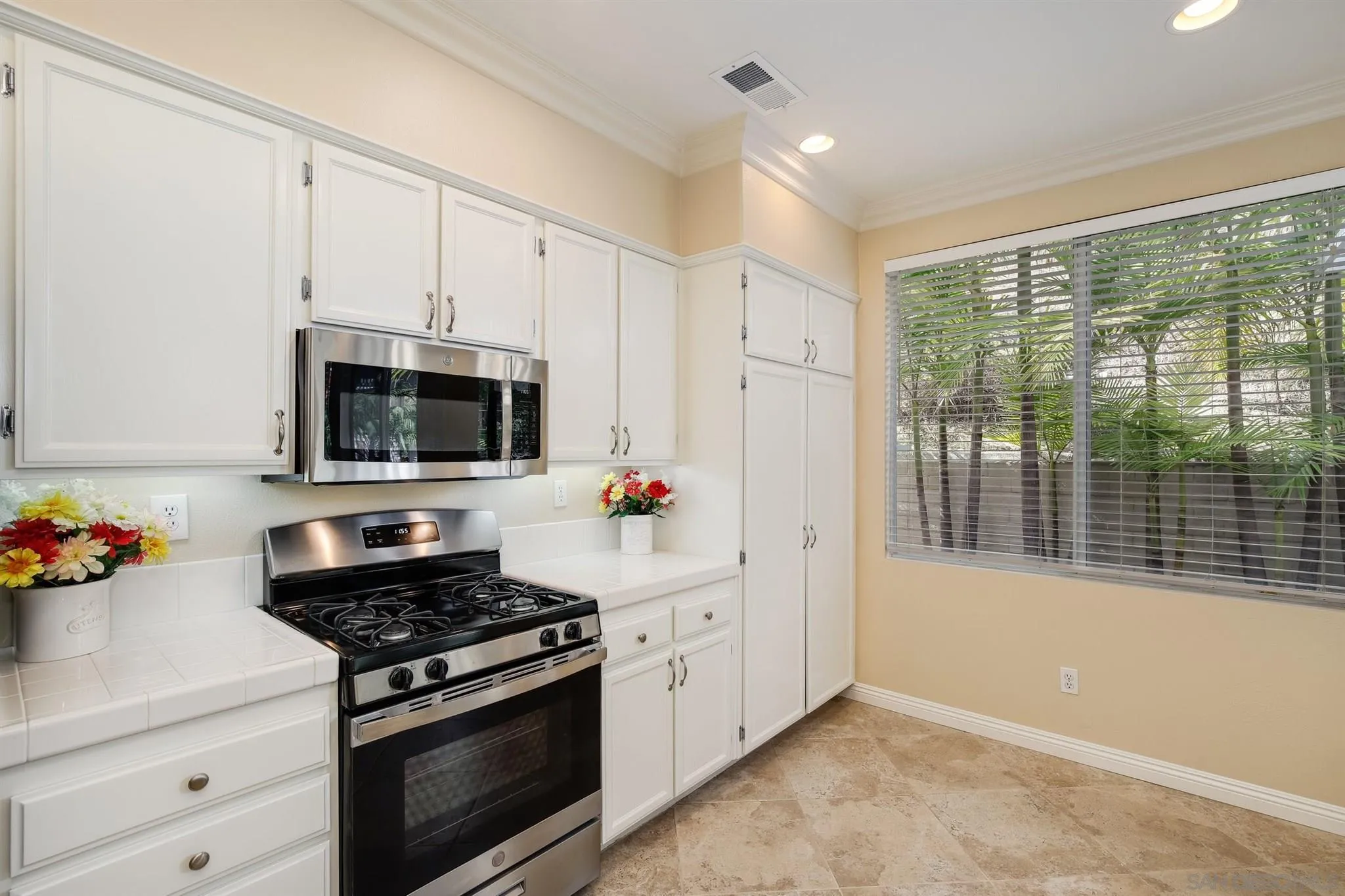 1983 Courage Street Vista, CA 92081 - Photo 13 of 33 a kitchen with stainless steel appliances white cabinets and a stove top oven