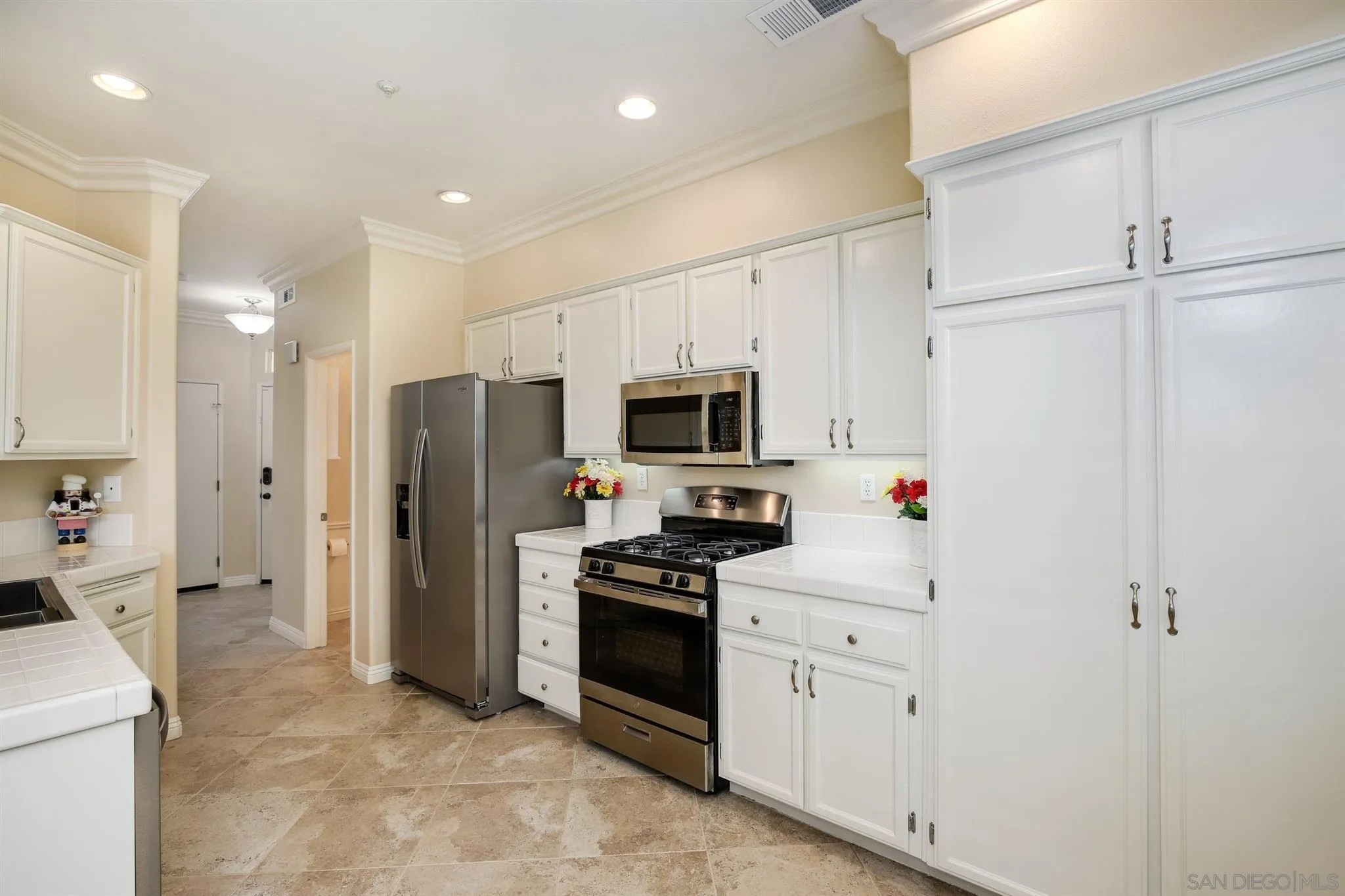 1983 Courage Street Vista, CA 92081 - Photo 8 of 33 a kitchen with white cabinets and white stainless steel appliances