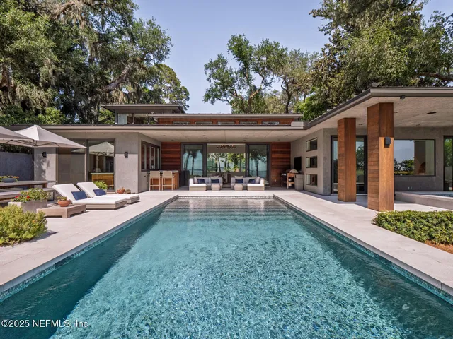a view of a patio with table and chairs potted plants and large tree