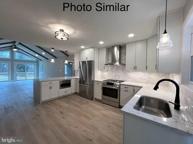 a kitchen with stainless steel appliances granite countertop a sink a stove and a refrigerator