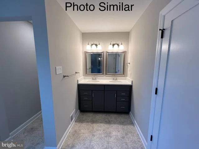 a bathroom with a double vanity sink and a mirror