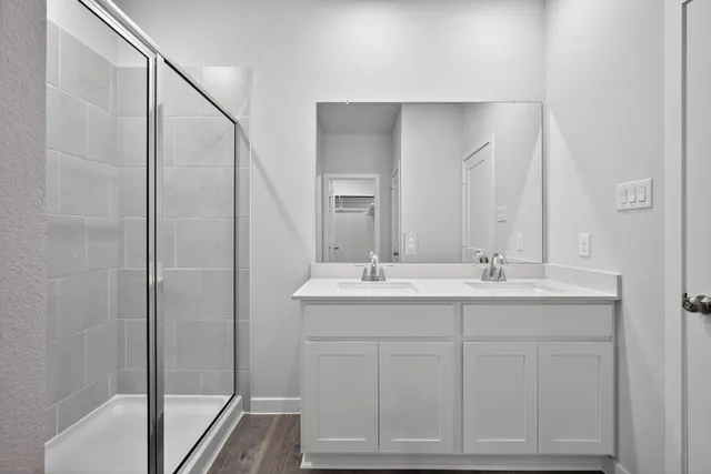 a bathroom with a double vanity sink mirror and shower