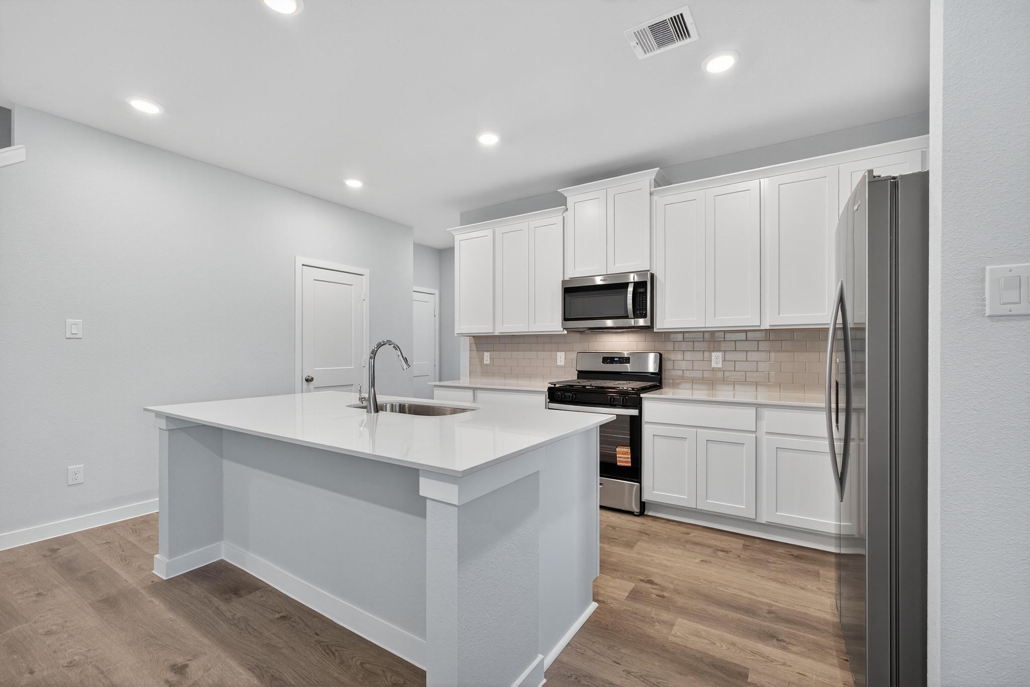3922 Accolade Crossing Brookshire, TX 77423 - Photo 4 of 27 a kitchen with stainless steel appliances granite countertop a sink stove and refrigerator