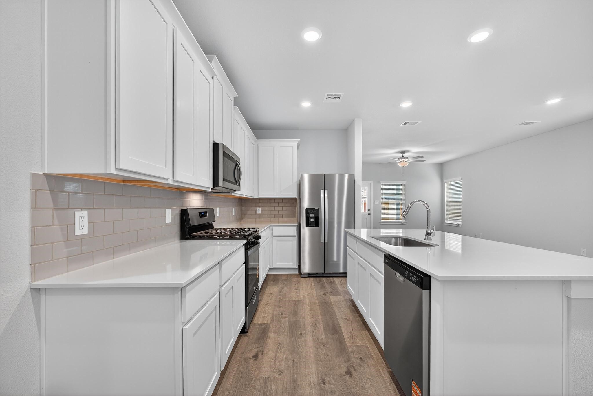 3922 Accolade Crossing Brookshire, TX 77423 - Photo 5 of 27 a kitchen with stainless steel appliances granite countertop a sink stove and refrigerator