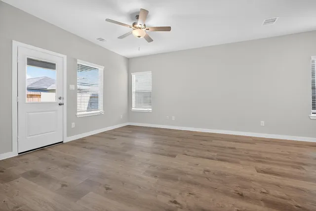 wooden floor in an empty room with a kitchen