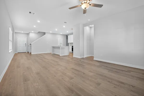 wooden floor in an empty room with a kitchen