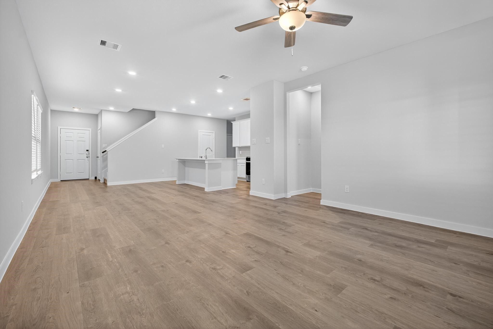 3922 Accolade Crossing Brookshire, TX 77423 - Photo 7 of 27 wooden floor in an empty room with a kitchen