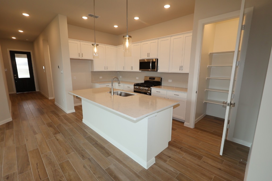 110 Afton June Drive Rosenberg, TX 77471 - Photo 10 of 19 a kitchen that has a lot of white cabinets and wooden floor