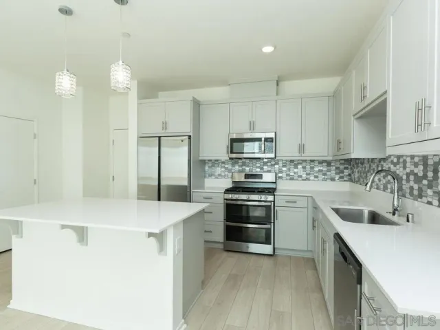 a kitchen with stainless steel appliances a sink stove and refrigerator