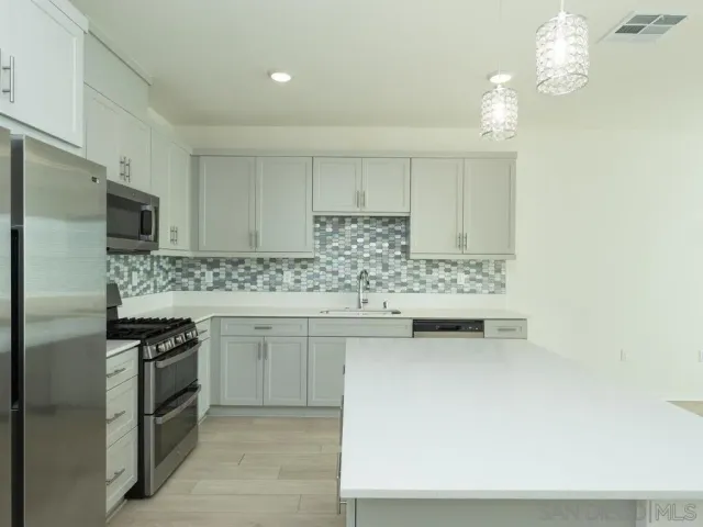 a kitchen with stainless steel appliances a sink stove and refrigerator