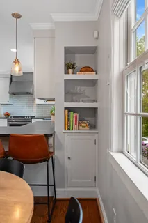 a kitchen with stainless steel appliances granite countertop a stove a sink dishwasher a microwave oven and a dining table with wooden floor