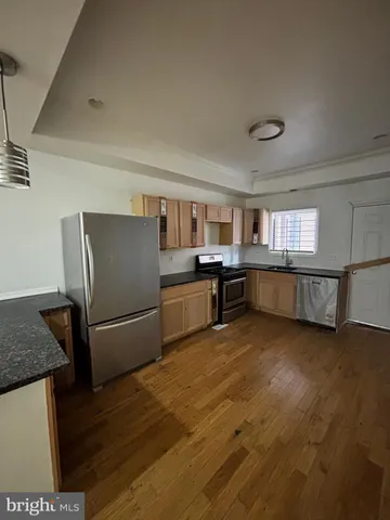 a kitchen with stainless steel appliances granite countertop a refrigerator and a stove