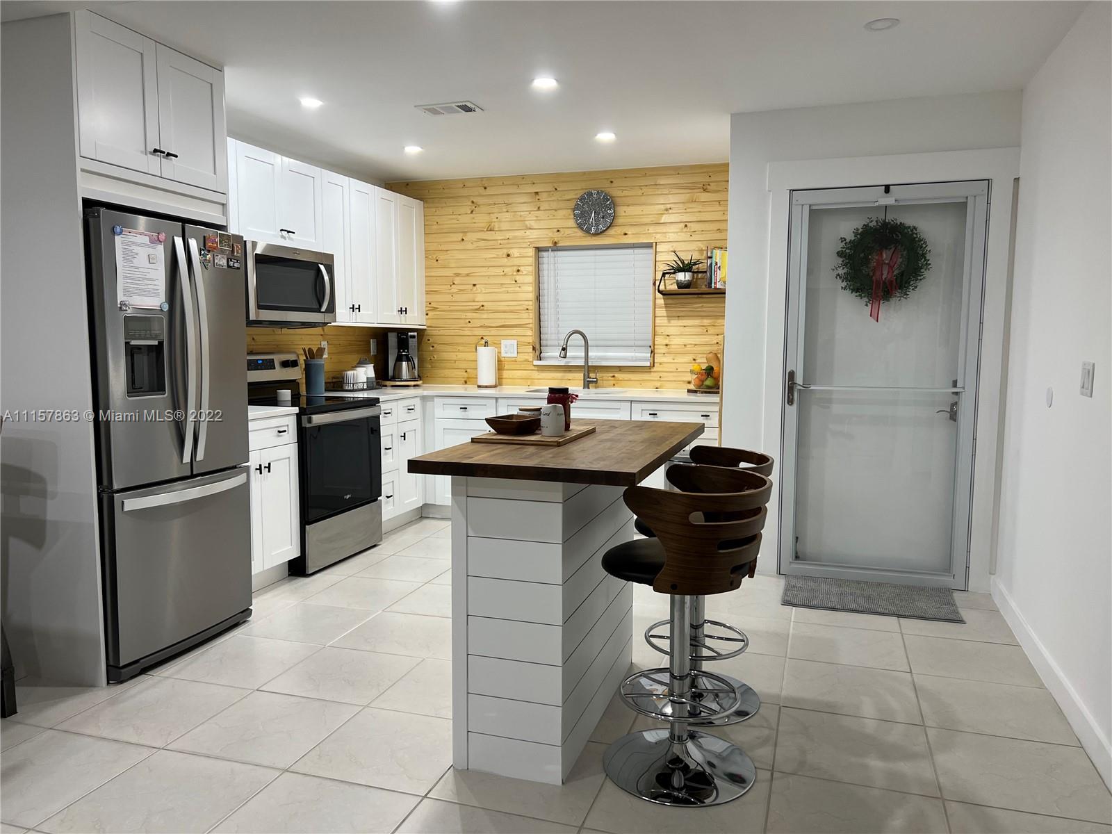 a kitchen with stainless steel appliances granite countertop a sink a stove a refrigerator and a refrigerator