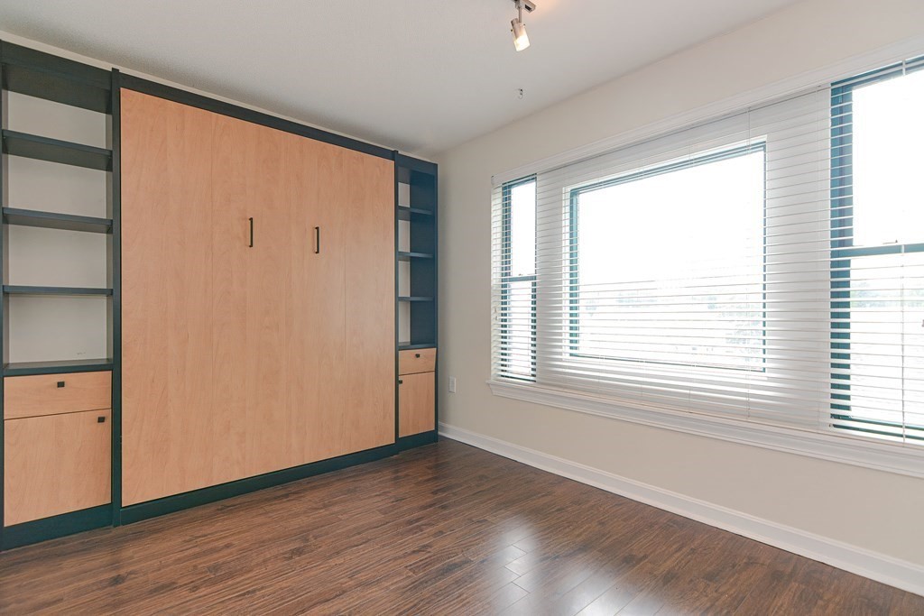 59 Brainerd Road, Unit 410 Boston, MA 02134 - Photo 19 of 41 a view of an empty room with wooden floor and a window