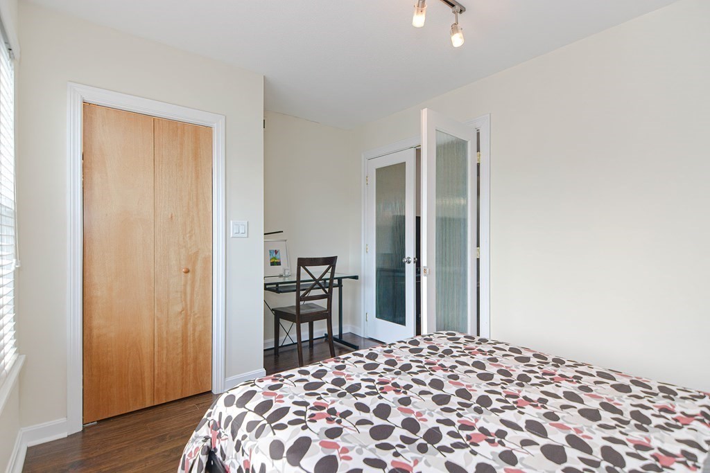 59 Brainerd Road, Unit 410 Boston, MA 02134 - Photo 21 of 41 a bedroom with a bed and wooden floor