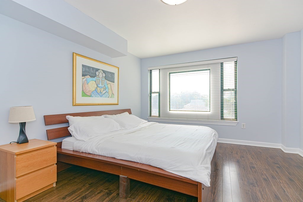 59 Brainerd Road, Unit 410 Boston, MA 02134 - Photo 23 of 41 a bedroom with a bed and wooden floor
