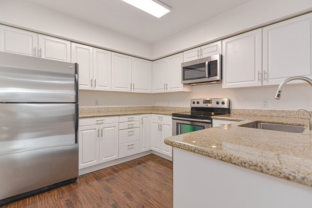 59 Brainerd Road, Unit 410 Boston, MA 02134 - Photo 8 of 41 a kitchen with granite countertop a refrigerator sink and cabinets