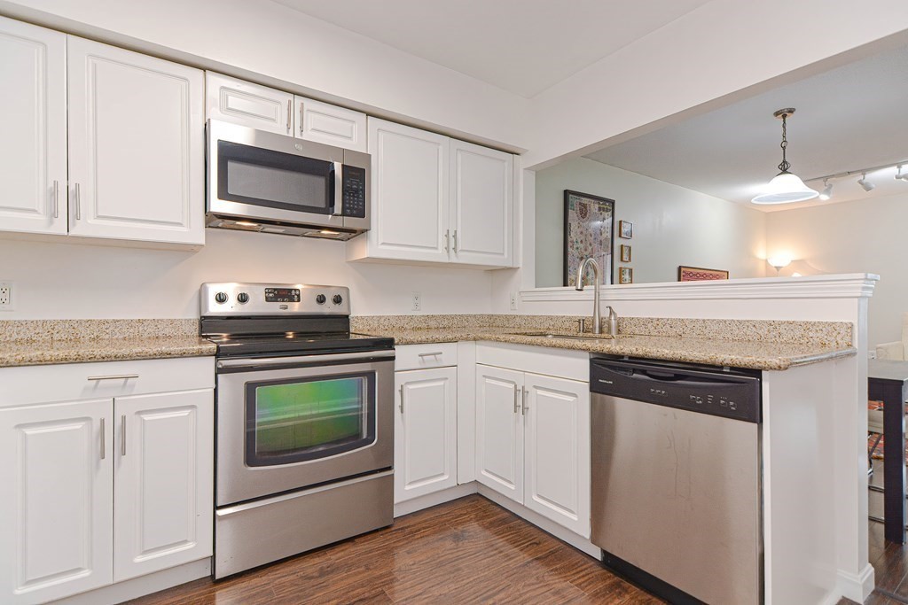 59 Brainerd Road, Unit 410 Boston, MA 02134 - Photo 9 of 41 a kitchen with granite countertop white cabinets white stainless steel appliances and a sink
