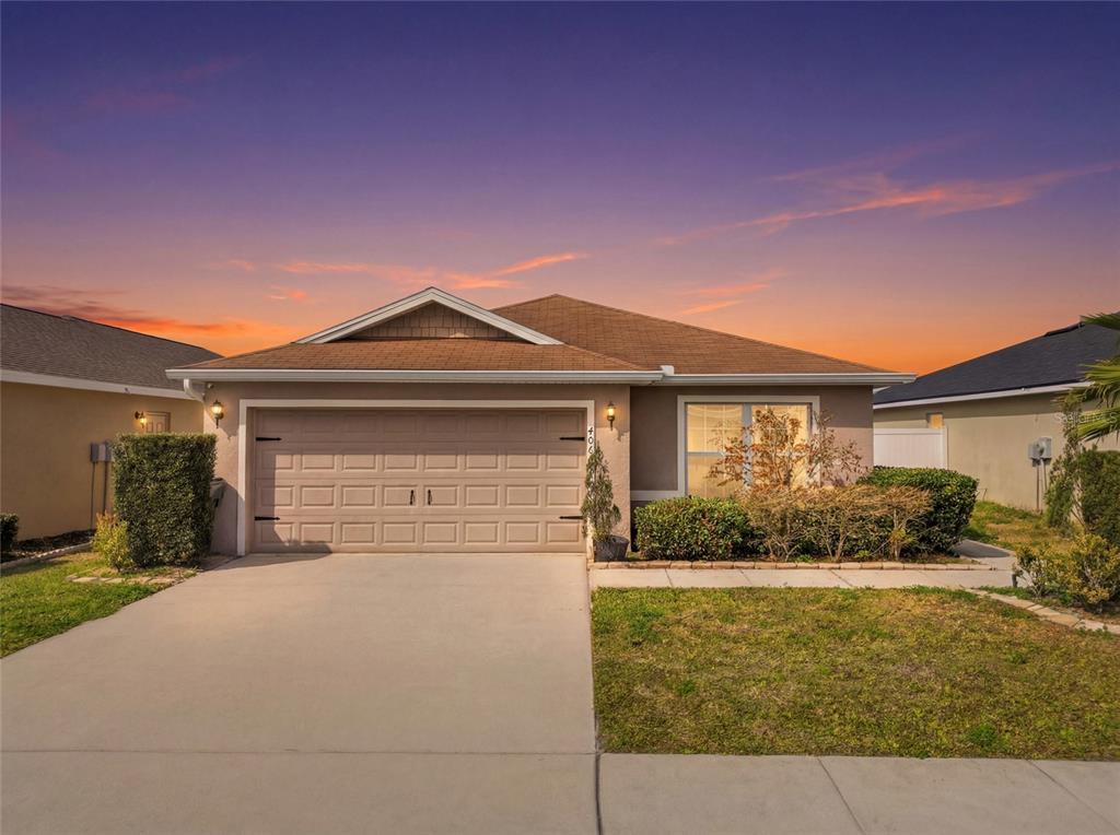 a front view of a house with a yard and garage