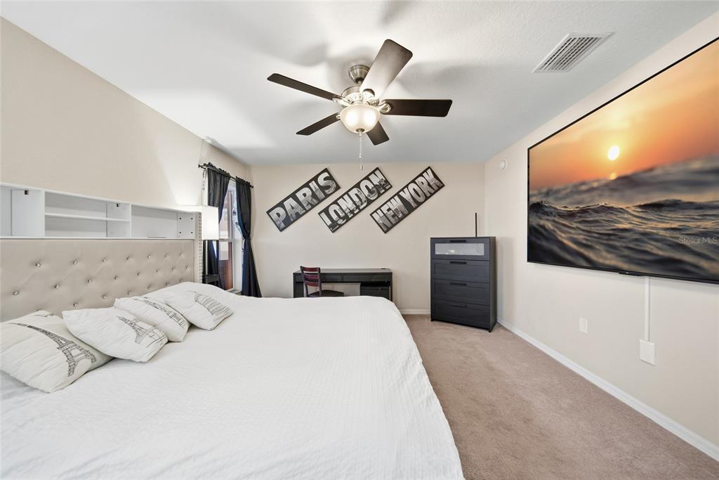4066 Sundance Pl Loop Mulberry, FL 33860 - Photo 11 of 28 a bedroom with a bed and a flat screen tv