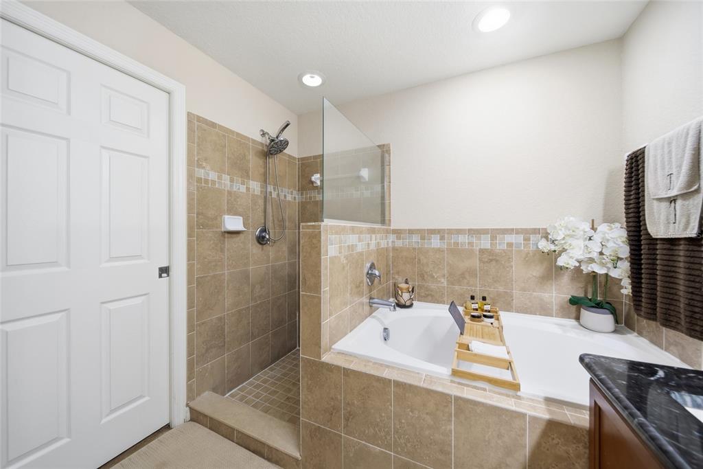 4066 Sundance Pl Loop Mulberry, FL 33860 - Photo 13 of 28 a bathroom with a bathtub and a shower