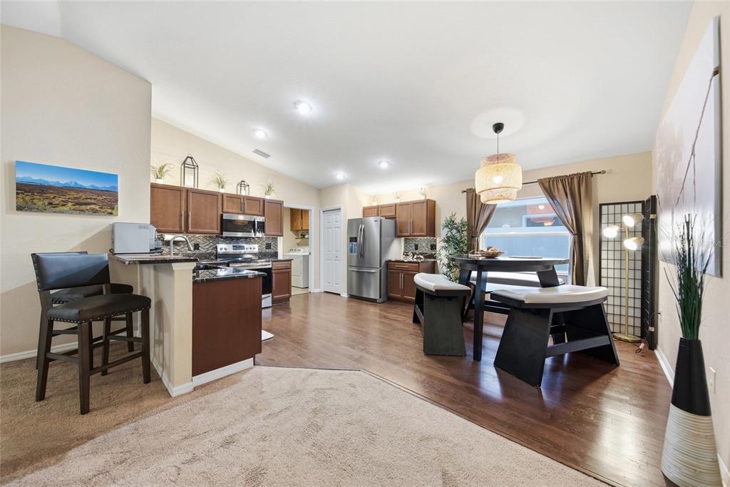 4066 Sundance Pl Loop Mulberry, FL 33860 - Photo 5 of 28 a view of kitchen with stainless steel appliances kitchen island a living room and a couch