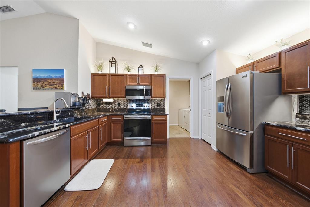 4066 Sundance Pl Loop Mulberry, FL 33860 - Photo 8 of 28 a kitchen with stainless steel appliances a refrigerator stove and sink