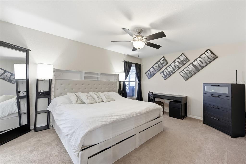 4066 Sundance Pl Loop Mulberry, FL 33860 - Photo 10 of 28 a bedroom with a large bed and a chandelier