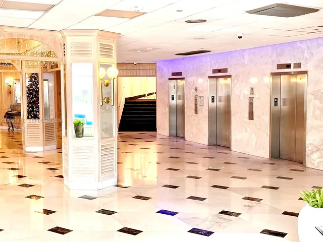 a view of a hallway with dining area and chandelier