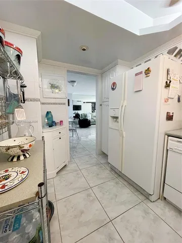 a kitchen with refrigerator and white cabinets