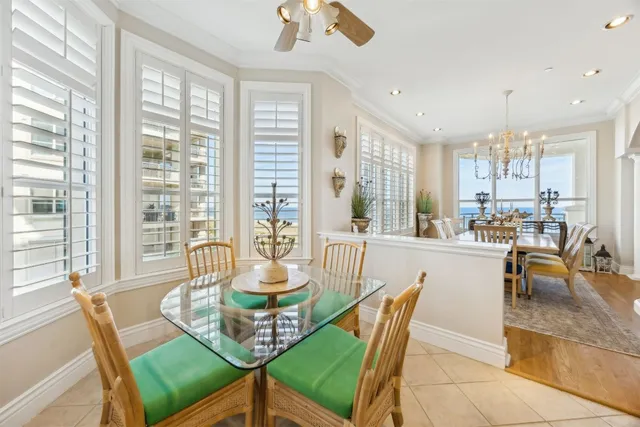 a dining room with furniture a chandelier and wooden floor