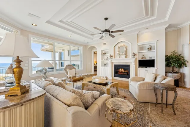 a living room with furniture a fireplace and a chandelier