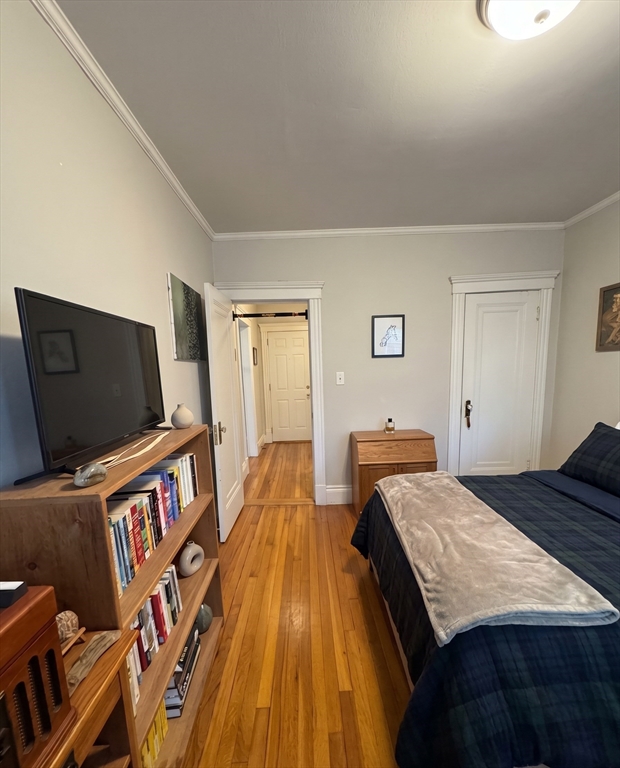 98 Strathmore Road, Unit 2 Boston, MA 02135 - Photo 4 of 11 a living room with a bed and a flat screen tv