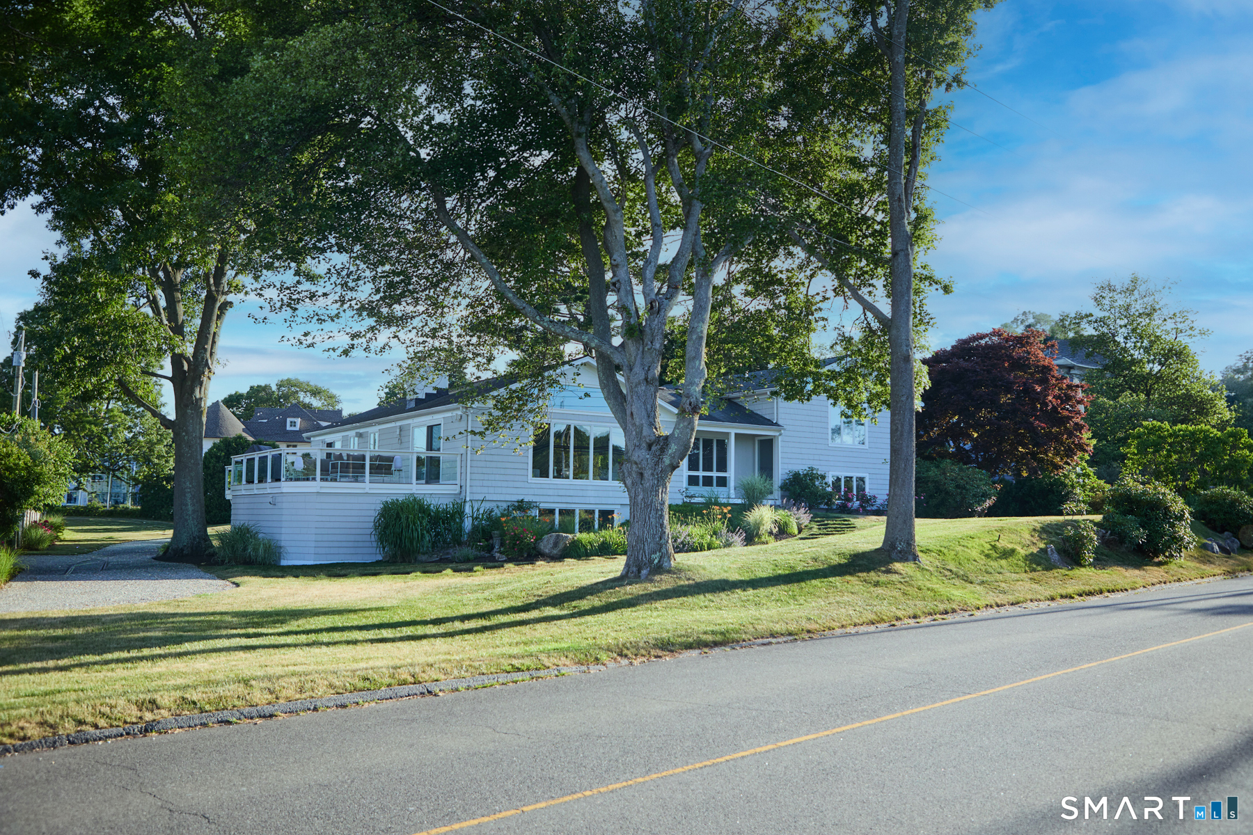 16 Harbor Road Westport, CT 06880 - Photo 1 of 36 a front view of a house with a garden and trees