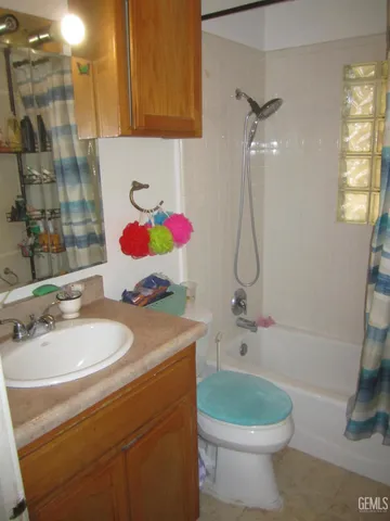 a bathroom with a sink a toilet and shower curtain