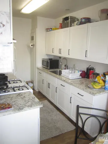 a kitchen with stainless steel appliances granite countertop a sink stove and cabinets