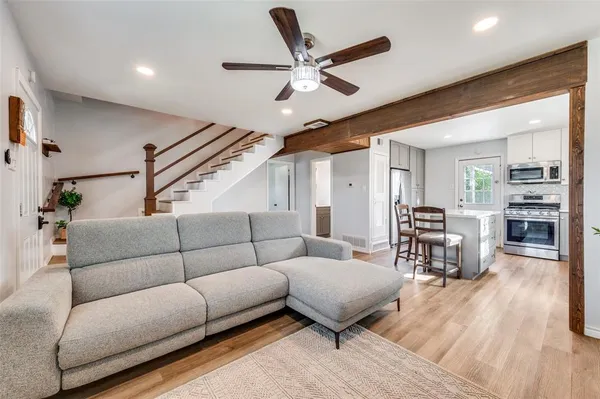 a living room with furniture and a wooden floor